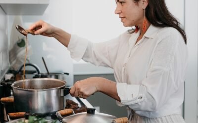 woman in white dress shirt holding stainless steel cooking pot